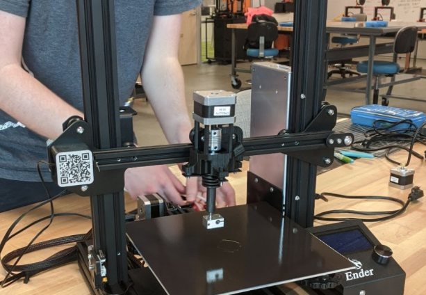 [Oscar busily working on securing wires behind our printer, complete with pellet extruder]